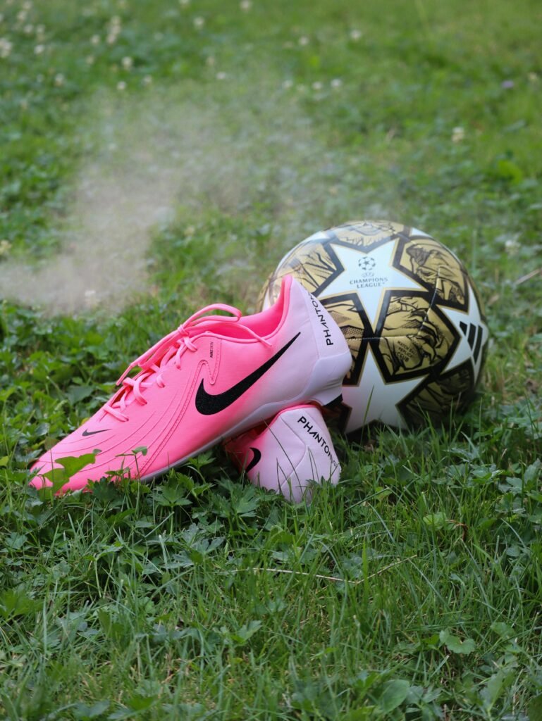 pexels-photo-27299916-27299916 Bright pink soccer cleats and ball on lush grass; perfect for sports themes.